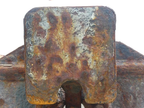 Rusted metal texture, formed into a rough, uneven surface in various hues of blue, yellow and red.